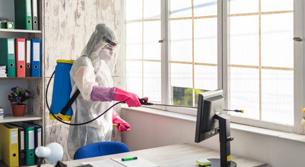 A sanitary officer cleans and disinfects an office from Covid 19